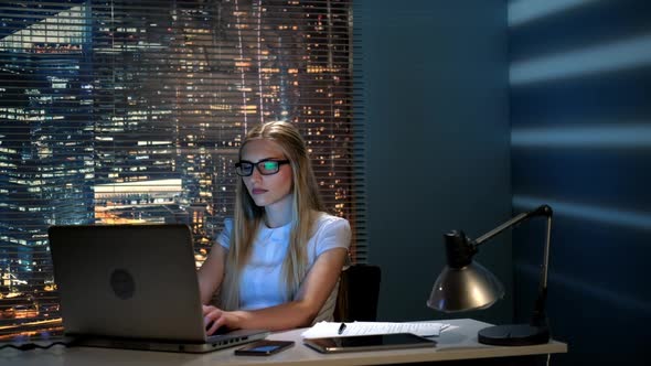 Beautiful Female Programmer Working on the Computer in Modern Office in the Evening