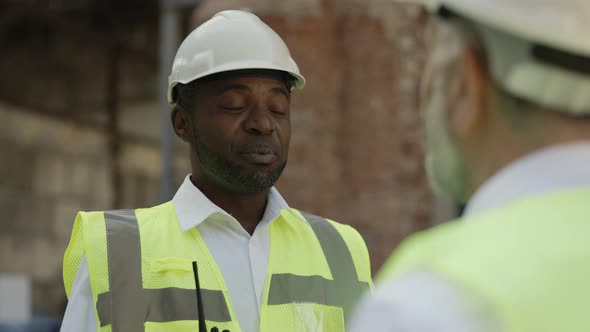 Colleagues Discussing Construction Project at Building Site