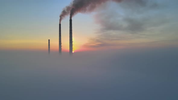 Aerial view of coal power plant high pipes with black smoke moving up polluting atmosphere