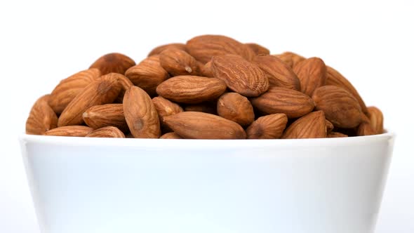 Almonds in bowl rotating close-up on white background