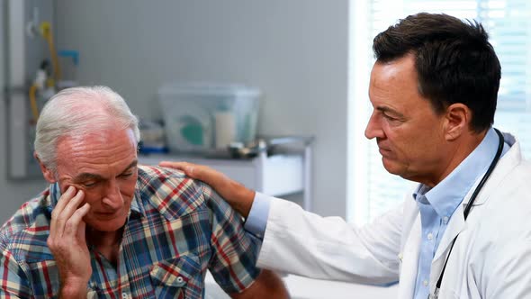 Doctor consoling senior man