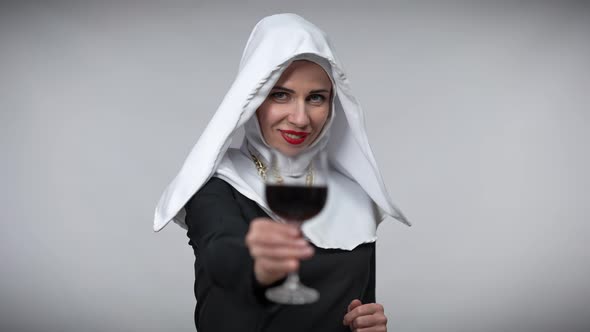 Beautiful Slim Woman in Nun Costume Toasting with Camera Smiling