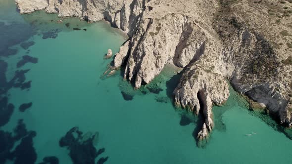 Exclusive hidden beach cove along the bright blue waters of the Mediterranean. Summertime Milos Gree