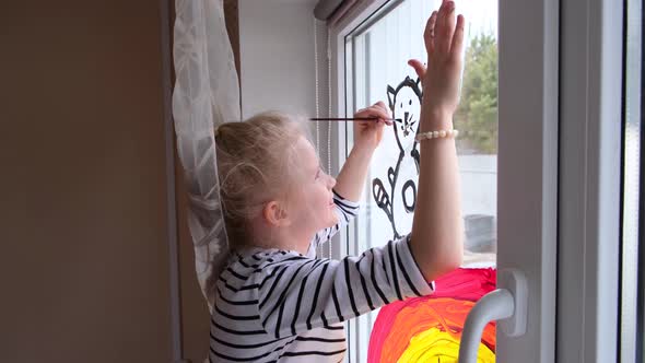 Girl Painting Rainbow and Cat on Window During Covid19 Quarantine at Home