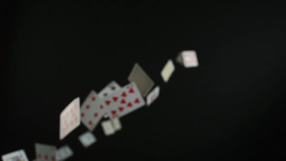 Playing cards falling on black background, Slow Motion alt