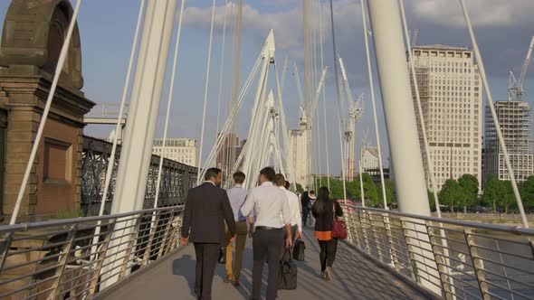 Business people and tourists walking on a bridge