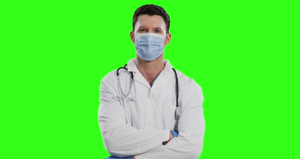 Caucasian male doctor wearing face mask on green screen background