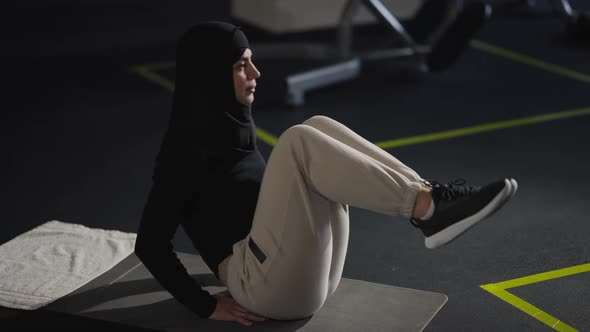 Side View Motivated Woman Pumping Press Lying on Exercise Mat in Gym Indoors