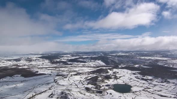 This is a footage of mountains in a snow day, you can also see big lakes and a village. This is in S