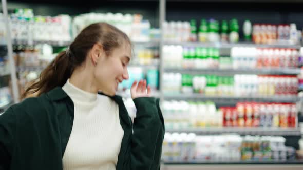 Happy Young Girl Funny Dancing Between Shelves in Supermarket