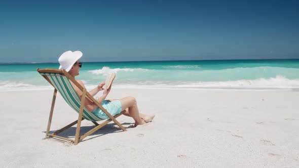 Man reading a book on the beach