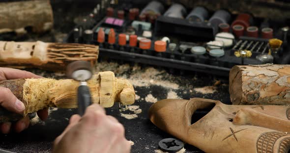 Close up male hands using power wood working tools graver