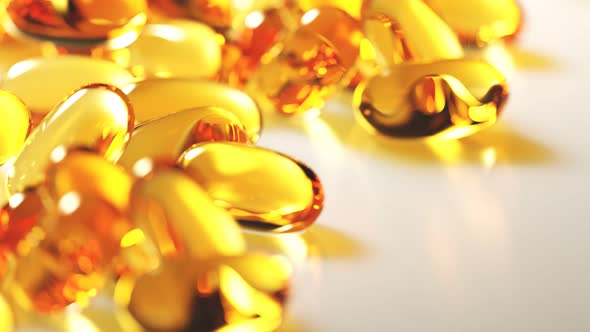 Seamless looping animation of yellow gel capsules with omega 3 or fish oil.