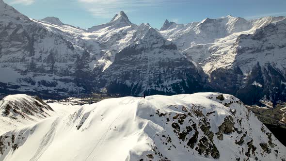 Aerial drone selfie shot of a snowboarder on a snowy mountain top in Switzerland