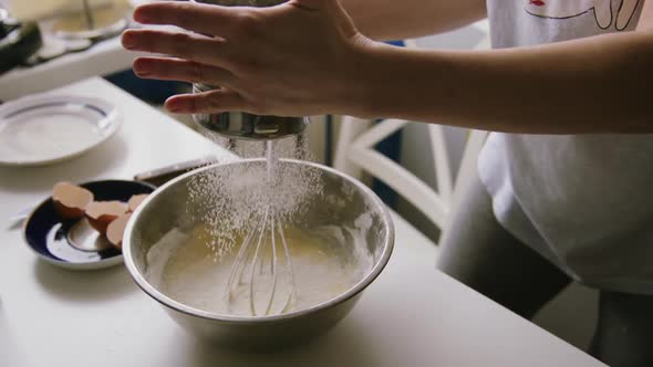 Woman Sifting Flour in a Bowl