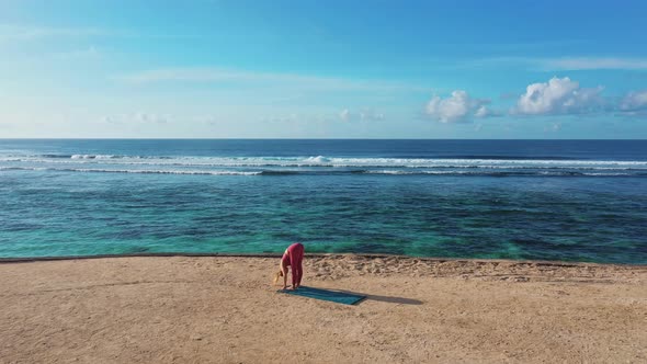 Drone Footage Woman Does Yoga Exercises and Stretches at Beach with Ocean View 