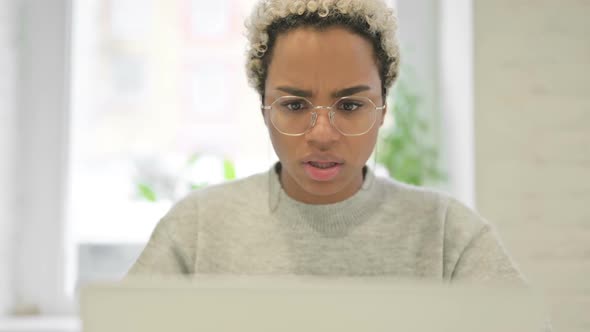 Close Up of African Woman Reacting to Loss on Laptop