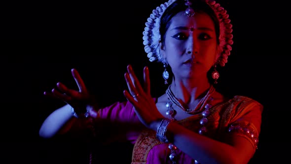 Female asian dancer perform, Odissi Indian traditional dance, 4k studio black backdrop color rgb led