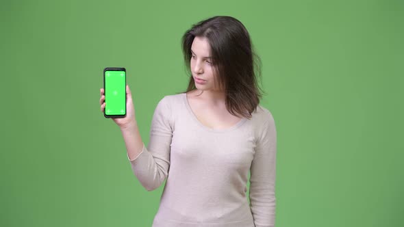 Young Beautiful Woman Showing Phone Against Green Background