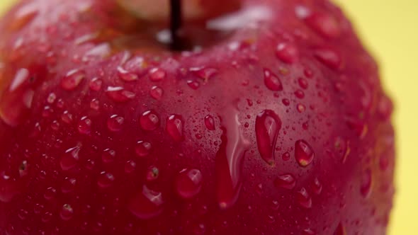 Water drops close-up on a red apple. Spraying fresh ripe fruit in slow motion. Macro