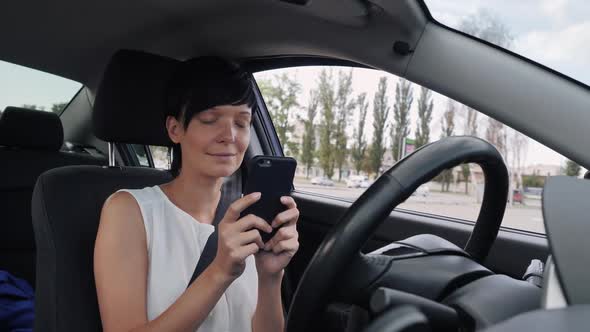 Smiling Female on Parking Lot Use Mobile