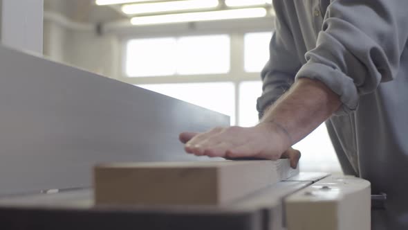 Caucasian Craftsman Smoothing Wood Board on Jointer at Workshop