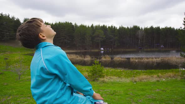 Deep breathing boy by the lake.