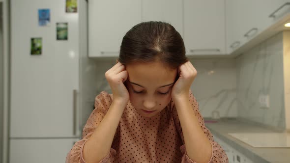 Upset Preteen Girl with Hanging Head Feeling Sad Scowling Indoors