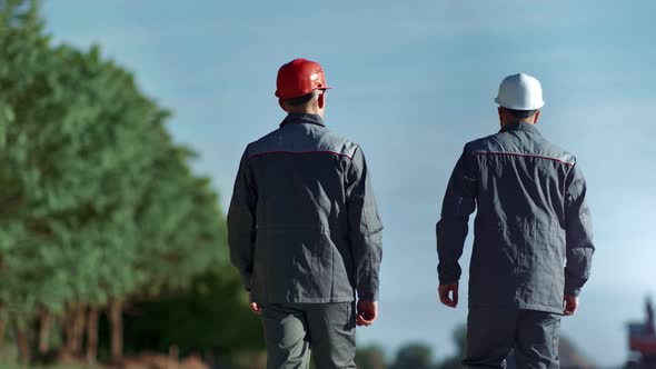 Industrial Male Foreman Discussing Working with Worker Man Walking Outdoor Back View