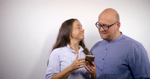 An Adult Couple on a White Background Go To Social Networks on the Internet with the Help