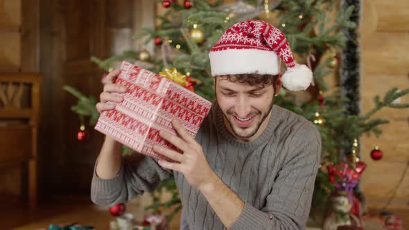 Man shaking a Christmas gift