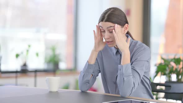 Upset Young Latin Woman Feeling Worried While Sitting in Office