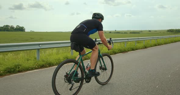 The Cyclist is Driving Quickly the Road and Changing Transmission