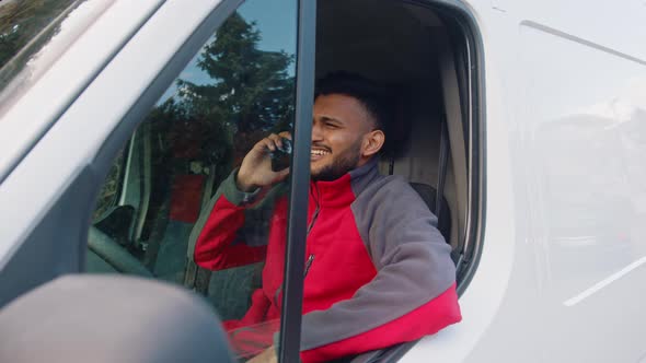 Indian Man Sitting in the Van and Having Phone Conversation