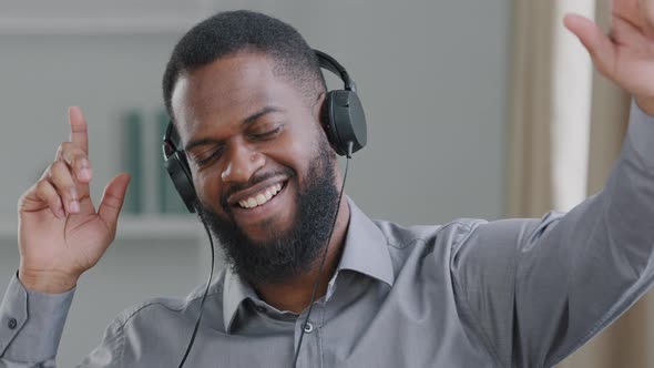 Happy Young African American Man Wearing Headphones Listening to Music Smiling Company
