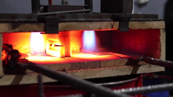 Metal detail burning in furnace in workshop