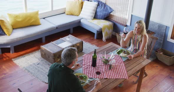 Happy caucasian mature couple smiling, talking and enjoying meal together