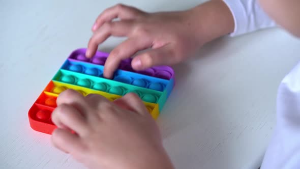 Girl Hands Close Up Playing with Rainbow Pop It Fidget