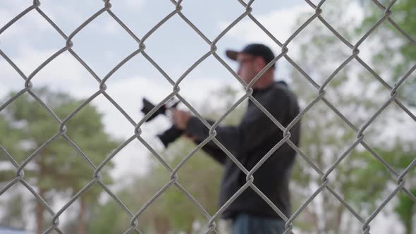 Looking through chain link fence at man with camera