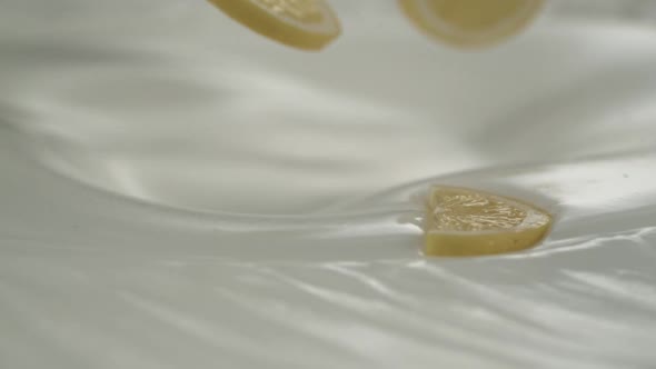 Fresh lemon slices rain on yogurt in slow motion – Close up