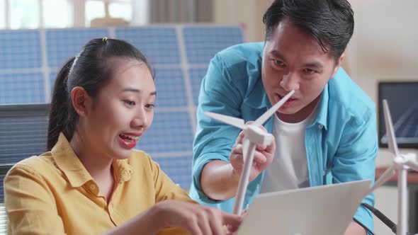 Close Up Of Asian Man And Woman Discuss About Work With Wind Turbine And Laptop Computer