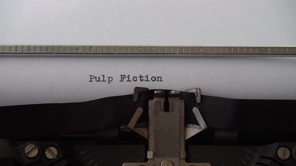 Typing phrase Pulp Fiction on retro typewriter. Close up.