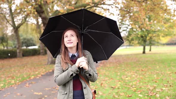 Happy woman portrait at park on a rainy day in London