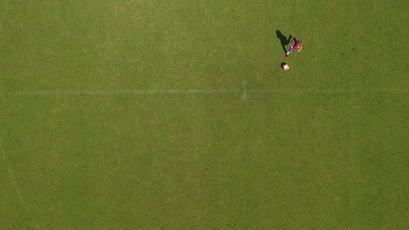 Slow motion shot of a young boy playing soccer on a soccer field