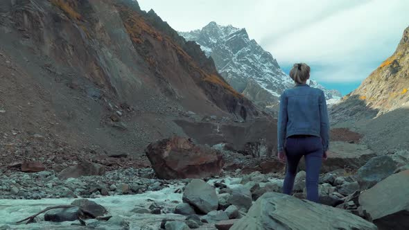 A young beautiful slender woman alone in the mountains.