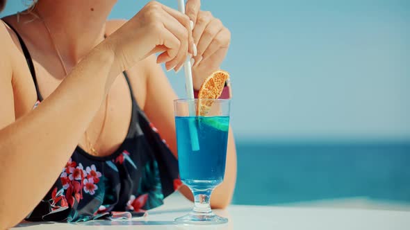 Woman Drinking Cocktail And Looking On Sea.Attractive Woman In Looking At Sea.Tequila Sunrise