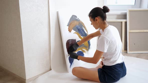 Brunette in White Tshirt and Black Shorts Draws Picture