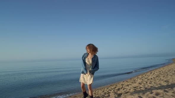 Smiling Curly Woman Posing on Sunny Beach