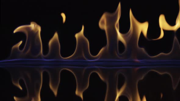 On a Black Reflective Background the Fire Ignites and Burns in Slow Motion
