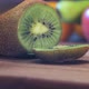 Professional Cook Cuts Ripe Kiwi Into Slices on Brown Board - VideoHive Item for Sale
